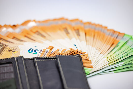 Abundance in a wallet with a fan of euro banknotes shot in studio on white background