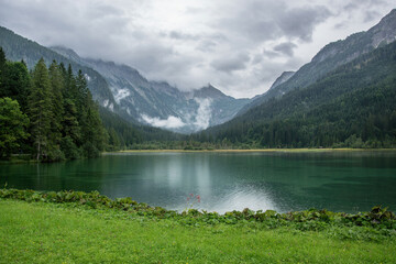 Lake Jagersee in Austria near the town of Wagrain. Water and high mountains in the clouds.