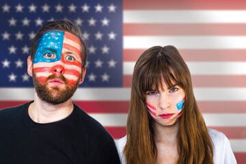 Angry fans of the usa soccer team anxiously watch the game during the world cup; happy u.s. football fans with painted faces and the u.s. flag in the background