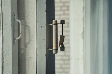 Old wooden window frame with broken handle close side view. Retro rustic window closeup.