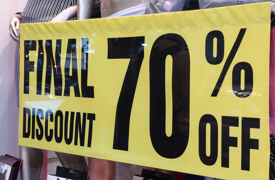 Final discount 70 percent OFF - inscription on banner on shop window in sale season.