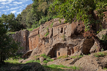 Viterbo, Lazio, Italy: Etruscan necropolis of Castel d'Asso, the facade and the entrance of the ancient tombs carved in the tufa rock - 548038738