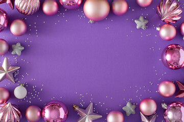 New Year eve concept. Flat lay composition of pink balls, stars and sequins on violet background...