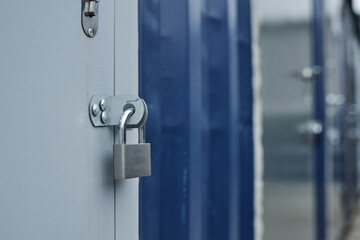 Closeup of metal lock on door of containers in shipping dock, copy space