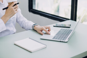 Woman hand using smart phone and laptop in outdoor nature park and sunset sky with bokeh light abstract background. Technology business and freelance working concept. Vintage tone filter color style.