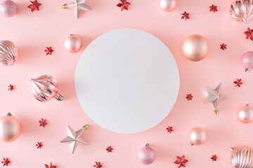 New Year decorations concept. Flat lay composition of christmas baubles and red stars on pastel...