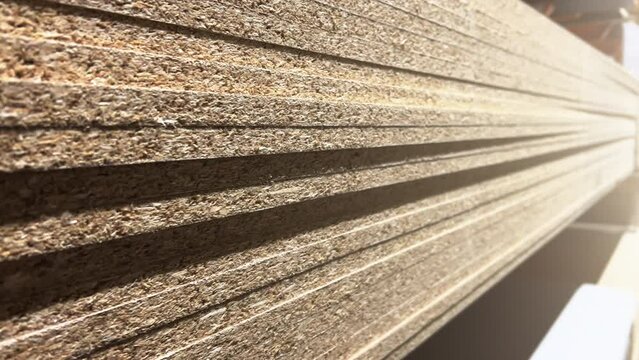 Stacks of sheet chipboard lie in the warehouse of a woodworking factory