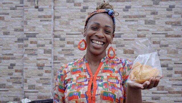 Retrato en video de una hermosa mujer latina afro caribe&ntilde;a muy sonriente viendo a c&aacute;mara y vendiendo sus alimentos  caribe&ntilde;os