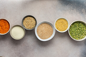 Fototapeta na wymiar Various grain cereals in bowls on a light background, top view