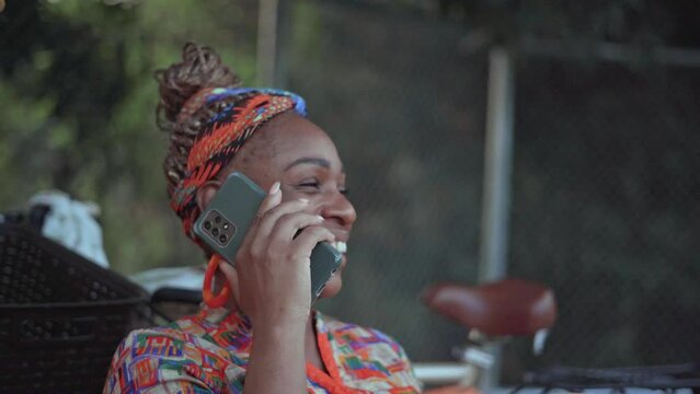 video en primer plano de una mujer afro caribeña muy sonriente hablando por celular 