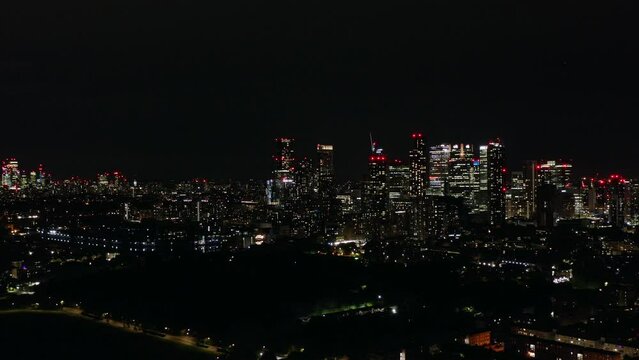 Fantastic view of the city at night, skyscrapers glittering white and red lights on the horizon, aerial shot.