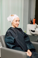 A woman with a towel on head. Hair washing, treatment in the hairdressing salon