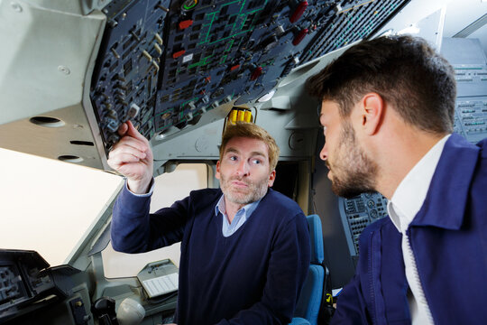 two pilots communicating and discussing in the cockpit