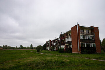Obraz premium old soviet apartment building on green field in Latvia countryside, village Kārniņi near Jelgava town