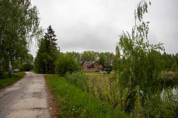 Fototapeta na wymiar old brick house near pond in overcast spring day