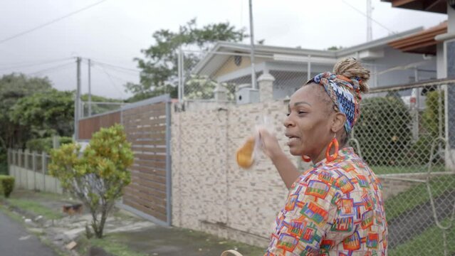 Imagen en video de una mujer afro caribe&ntilde;a con ropa colorida vendiendo en la calle sus productos en una bicicleta 