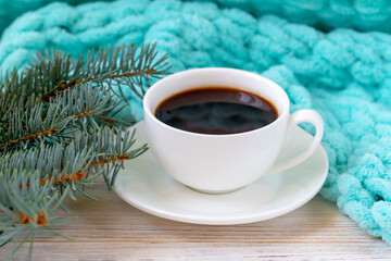 Obraz na płótnie Canvas A cup of coffee, a plaid, and a fir branch