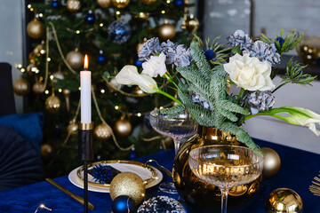 Festive Christmas table with flowers and candles. Atmosphere of New Year and Christmas. Beautiful happy lights. Serving a gala dinner