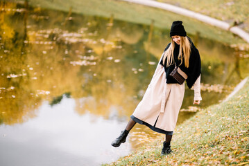 young beautiful girl is resting in nature. woman walking in the park on sunny autumn day