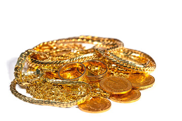 Goldschmuck, Goldmünzen und Goldbarren vor weißem Hintergrund