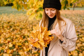 young beautiful girl is resting in nature. woman walking in the park on an autumn day