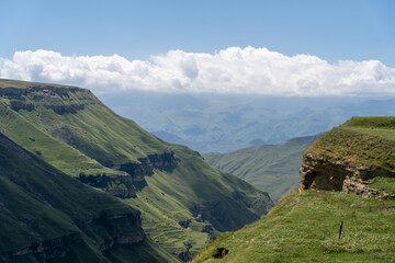 Beautiful sunny day in mountain valley and mountainous countryside landscape in summer. Mountain range under cloud blue sky.