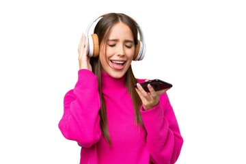 Young beautiful caucasian woman over isolated background listening music with a mobile and singing