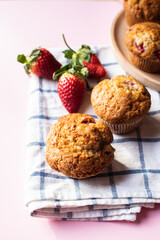 Strawberry muffins on a napkin on a pink background. Close up. - 548052597
