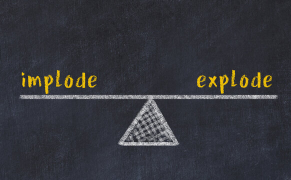 Concept of balance between implode and explode. Chalk scales and words on it