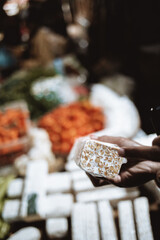 Asian person showing inside of tempeh at a food market
