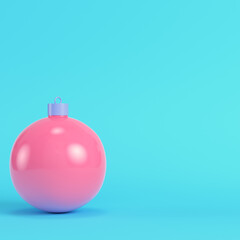 Pink christmas bauble on bright blue background in pastel colors. Minimalism concept