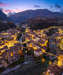 Fototapeta premium Beautiful aerial night cityscape of little town in Bergamo at blue hour, San Giovanni Bianco, Bergamo, Val Brembana, Lombardy, Italy