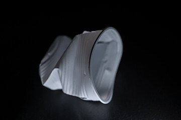 Crumpled disposable plastic cup. white cup on black background. to use in presentations or as a background