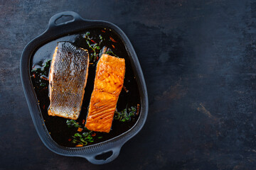 Traditional Japanese salmon fish teriyaki filet with soy souce and spinach as top view in a Nordic...
