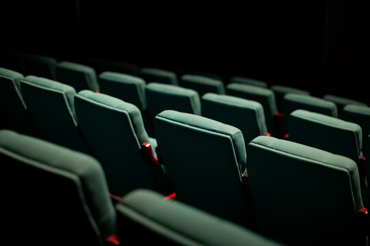 vacant green theater seats in dark room
