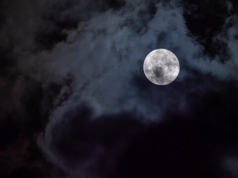 Full moon in the night sky among the clouds