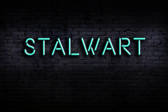 Neon sign. Word stalwart against brick wall. Night view
