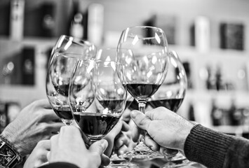 Happy friends making cheers with glasses of red wine