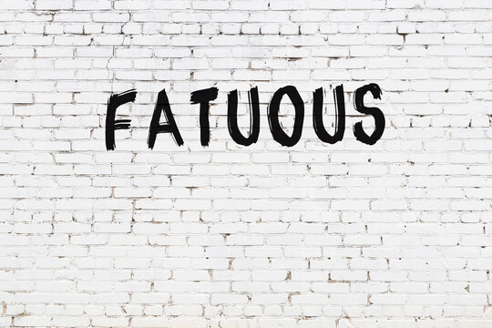 White wall with black paint inscription fatuous on it