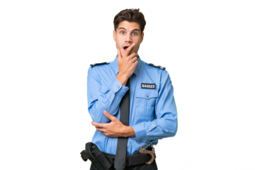 Young police man over isolated background surprised and shocked while looking right