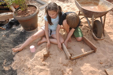 crianças brincando na areia em obra 