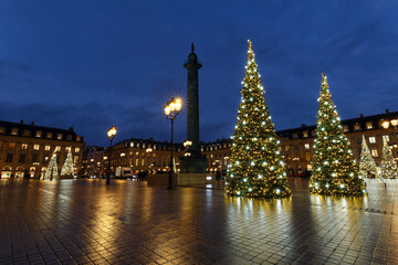 Fototapeta premium Vendome column with statue of Napoleon Bonaparte, on the Place Vendome decorated for Christmas at rainy night , Paris, France.