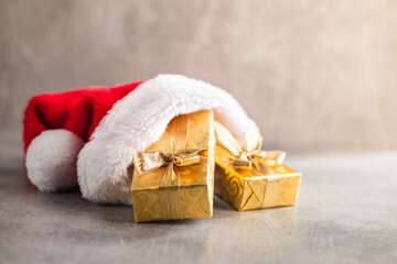 Gold christmas gift in red Santa hat.