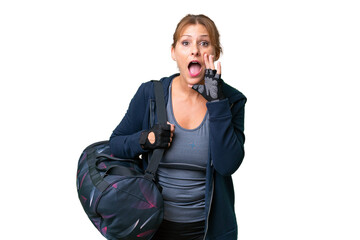 Fototapeta premium Middle-aged sport woman with sport bag over isolated background shouting with mouth wide open
