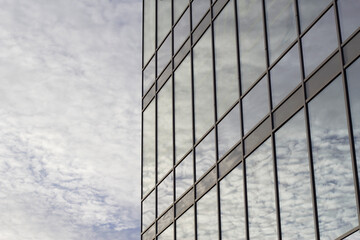 modern glass office building with cloudy sky reflection