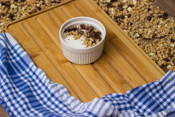 Granola in a bowl surrounded by granola on table. Granola background