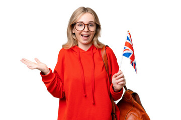 Young hispanic woman holding an United Kingdom flag over isolated background with shocked facial expression