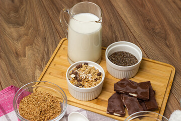 Bowl of chocolate granola with milk and other ingredients
