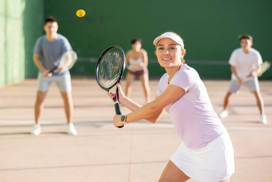 Expressive resolved fit girl playing frontenis ball friendly match on outdoors court