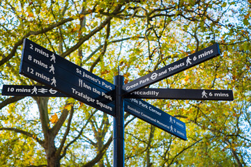 Guide arrows showing different popular directions and walking distances in London city tourist area. London sightseeing signpost.